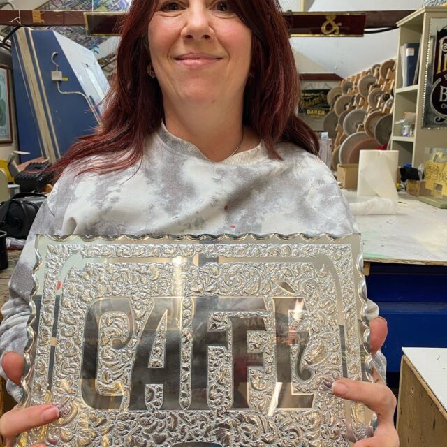 Me holding the glue chipped glass CAFFE sign produced at David Smith's glass gold leaf masterclass