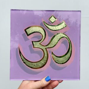 Reverse glass gold leaf Ohm symbol on a light violet background