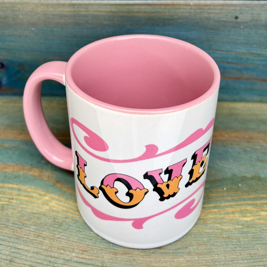 White & pink ceramic mug with Circus Style hand-lettered ‘LOVE’ design