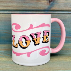 White ceramic 11oz mug with circus style LOVE lettering design wrap around and colourful pink rim, handle and inside, side view