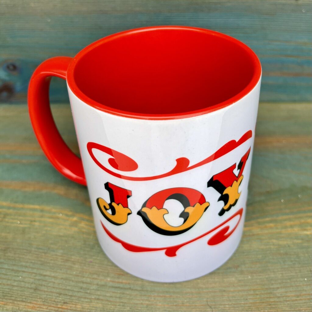 White & red ceramic mug with Circus Style hand-lettered ‘JOY’ design