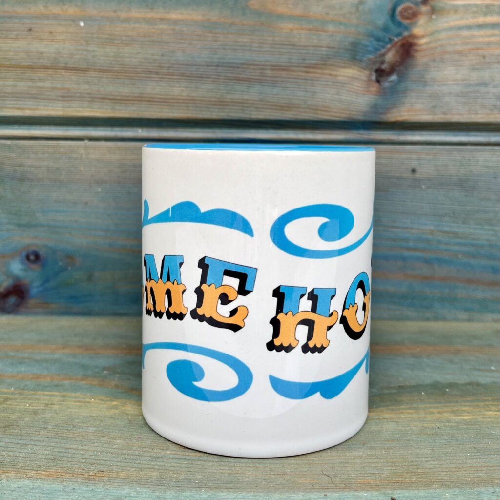 White & blue ceramic mug with Circus Style hand-lettered ‘HOME’ design