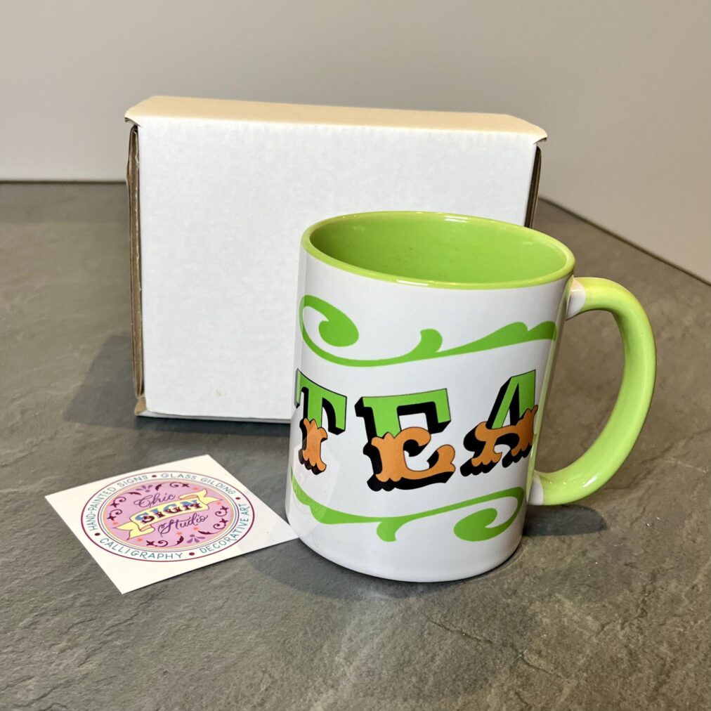 White & green ceramic mug with Circus Style hand-lettered ‘TEA’ design with postage box