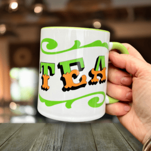 Hand holding Circus Style hand-lettered ‘TEA’ Mug with colour inside