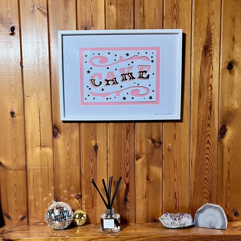 CAKE papercut lettering art A3 poster in a white frame