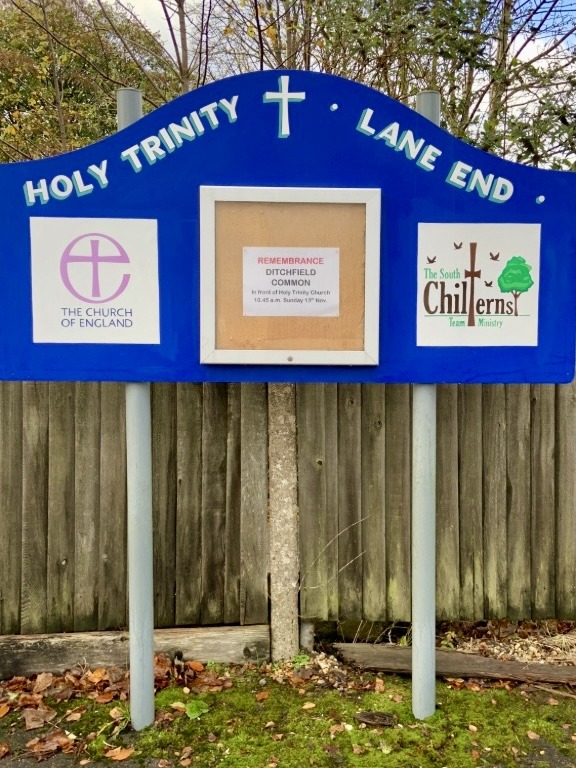 Handpainted sign for Holy Trinity church with logs for the diocese white lettering on blue background