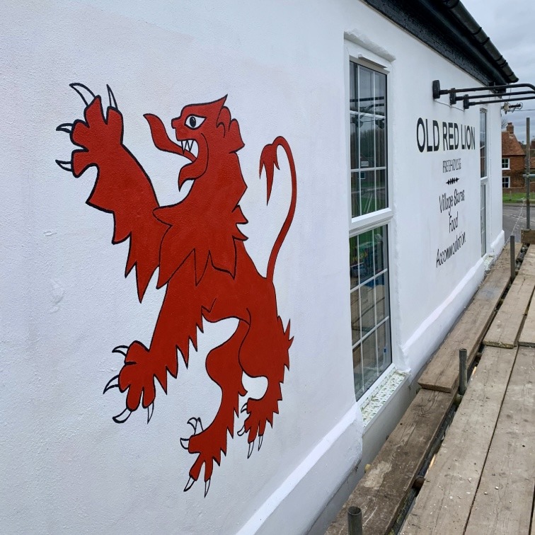 Red Rampant Lion painted onto white wall of The Old Red Lion pub in Thame