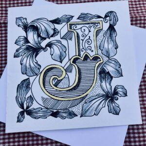 Beautifully hand-drawn ornamental letter J featuring intricate acanthus leaf detailing and handfinished gold outlining